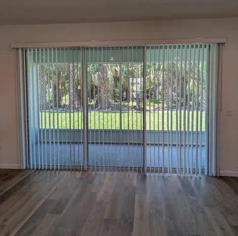 Custom vertical blinds covering a wide sliding glass door in a Ponte Vedra home
